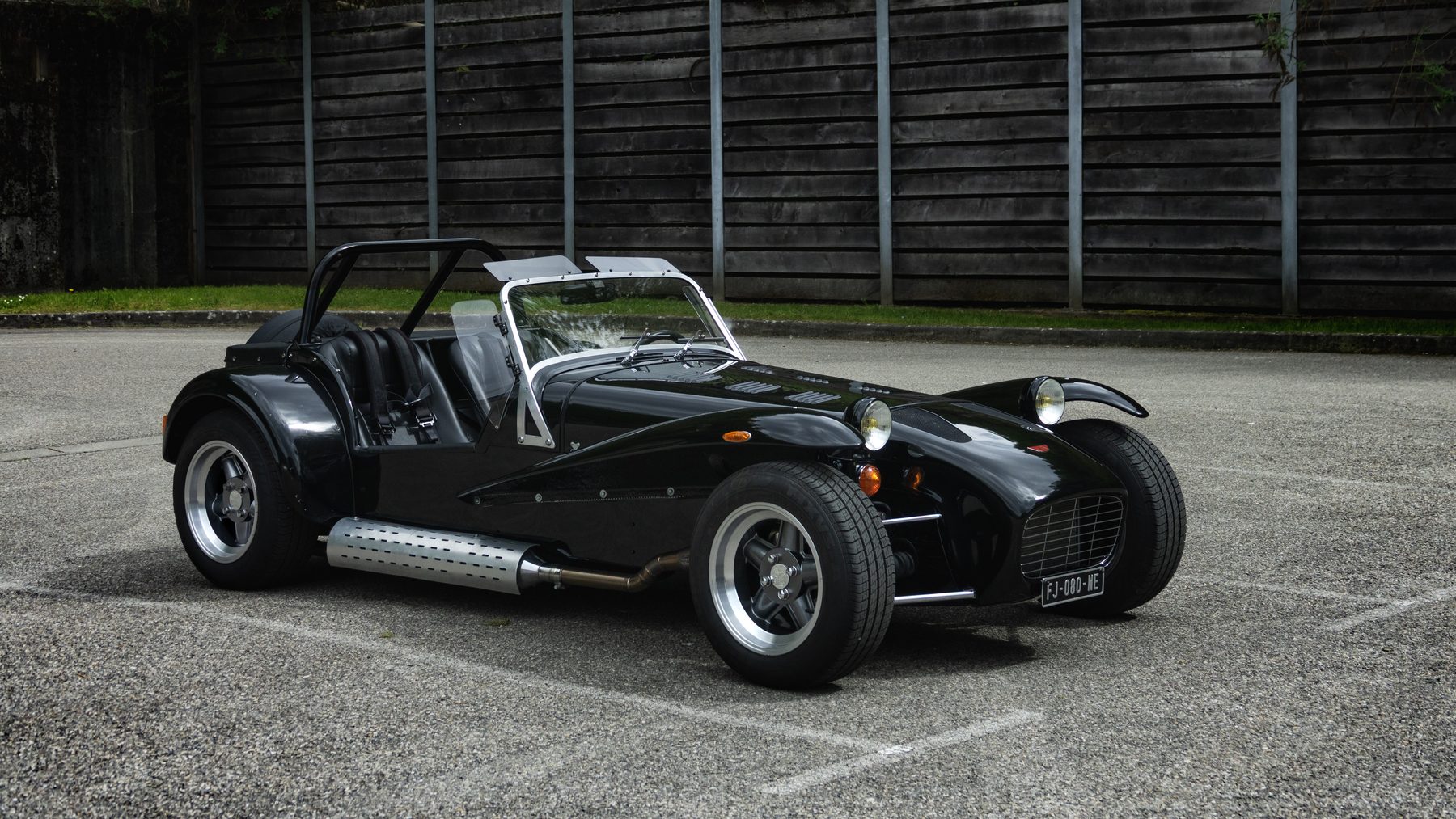 Roadster noir type Seven photographié sur du gravier